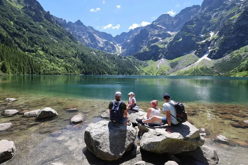 zdjęcie: Turyści szukają ochłody w tatrzańskich stawach; za kąpiel grożą mandaty / Morskie Oko, 25.06.2026. Turyści w gorący dzień nad Morskim Okiem, 25 bm. Dzisiaj w Tatrach +28 st. C. (aldg) PAP/Grzegorz Momot