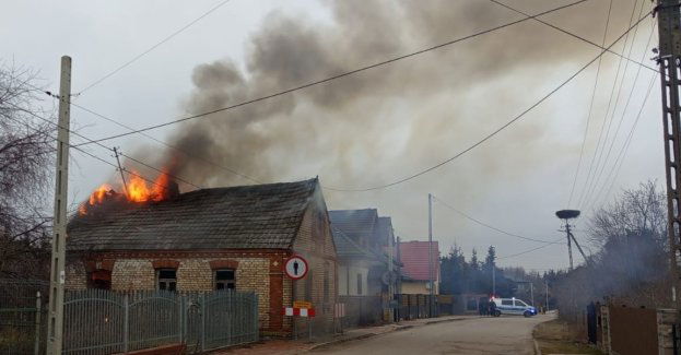 Policjanci razem ze świadkiem wyprowadzili mężczyznę z płonącego budynku
