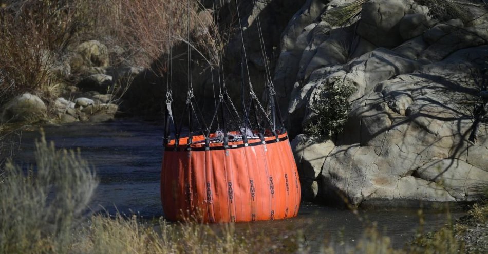 zdjęcie: ćwiczenia policyjnych lotników oraz strażaków z użyciem śmigłowca Black Hawk z Bambi Bucket, trzytonowym zbiornikiem na wodę / fot. PAP