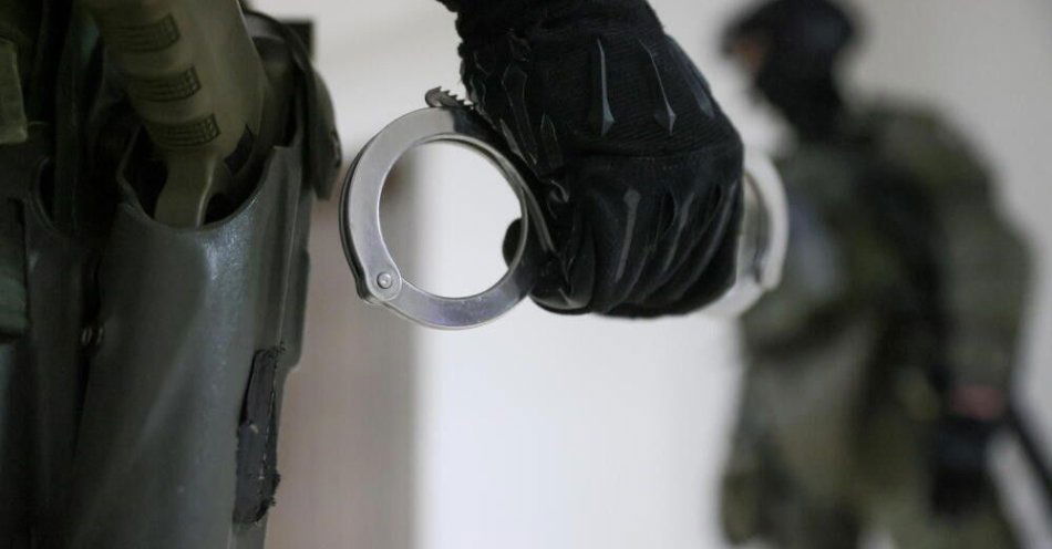 zdjęcie: CBŚP rozbiło gang narkotykowy działający na Podlasiu, zabezpieczono ponad 130 kg narkotyków / Warszawa, 19.12.2022. Funkcjonariusz CBŚP trzymający kajdanki - zdjęcie ilustracyjne. (ls/ibor) PAP/Leszek Szymański