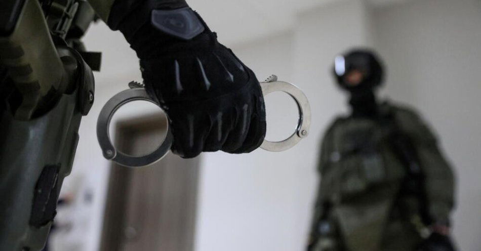 zdjęcie: Służby rozbiły gang zajmujący się legalizacją pobytu cudzoziemców, zatrzymały 24 osoby / Warszawa, 19.12.2022. Funkcjonariusz CBŚP trzymający kajdanki - zdjęcie ilustracyjne. (ls/ibor) PAP/Leszek Szymański