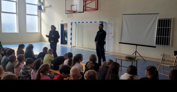 Dzielnicowy i policjantka uczą dzieci nowych przepisów drogowych